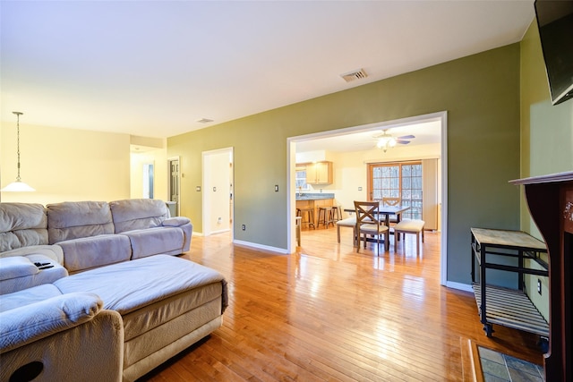 living room with light hardwood / wood-style flooring and ceiling fan