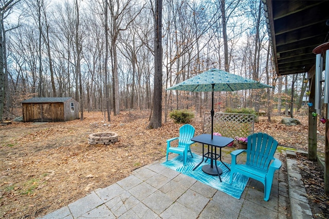 view of patio featuring a shed and an outdoor fire pit