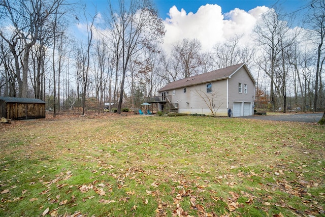 view of yard with a garage, a deck, and a storage shed