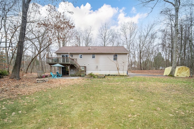 back of property with a wooden deck, a yard, and a shed