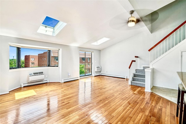 unfurnished living room featuring a skylight, ceiling fan, light hardwood / wood-style flooring, and a baseboard radiator