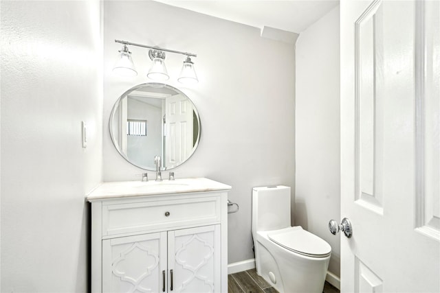 bathroom featuring wood-type flooring, vanity, and toilet