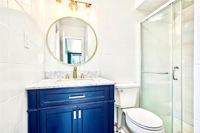 bathroom featuring decorative backsplash, vanity, tile walls, toilet, and a shower with shower door