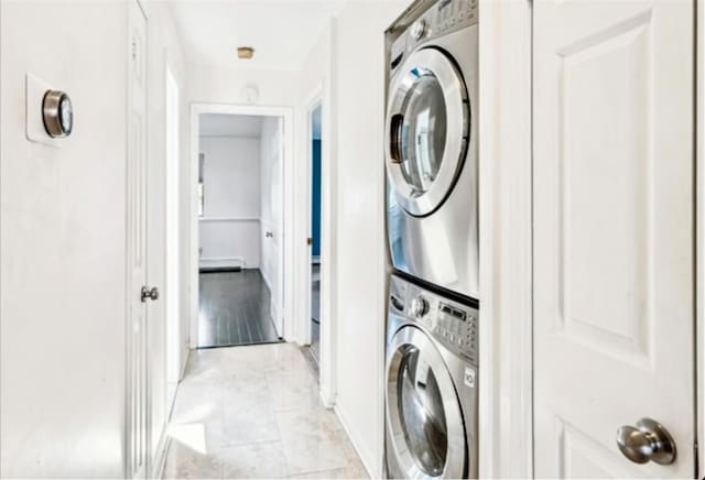 laundry room featuring light hardwood / wood-style floors and stacked washer / drying machine