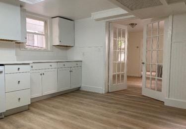 kitchen featuring white cabinets, french doors, and light hardwood / wood-style floors