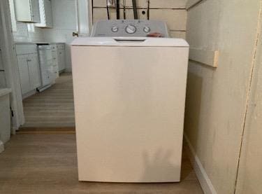 laundry area with washer / clothes dryer and light hardwood / wood-style flooring