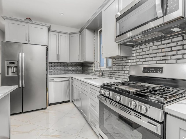 kitchen featuring backsplash, gray cabinetry, sink, and appliances with stainless steel finishes