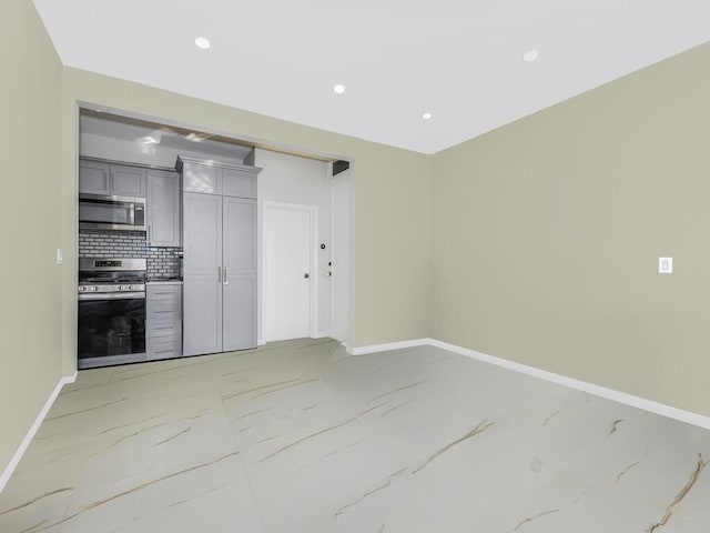 kitchen featuring tasteful backsplash, gray cabinets, and stainless steel appliances