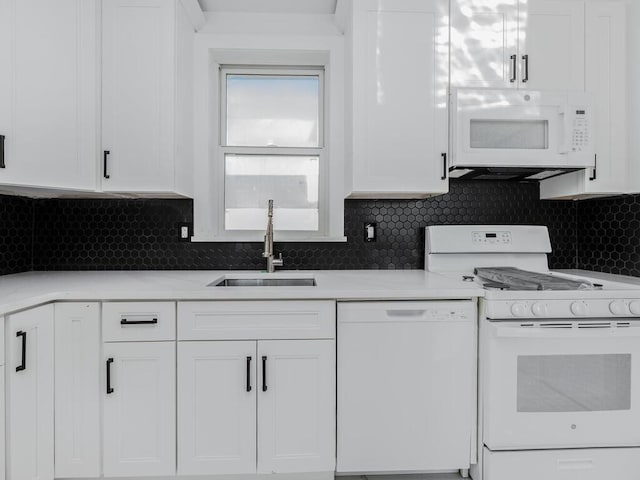 kitchen featuring white appliances, tasteful backsplash, white cabinetry, and sink