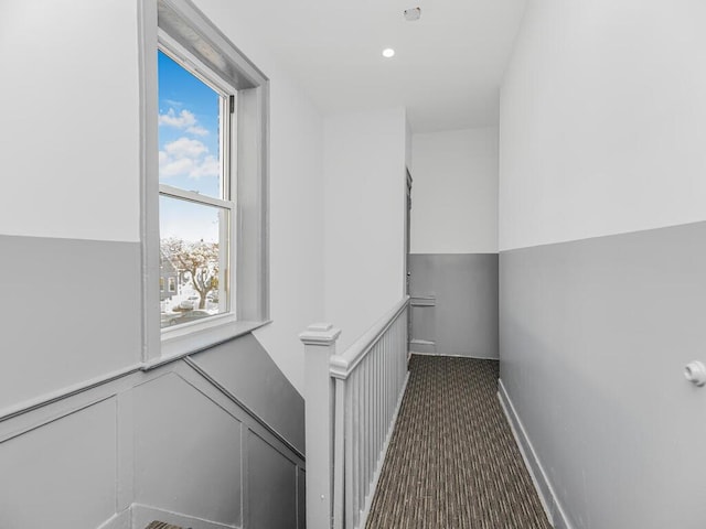 hallway with dark colored carpet