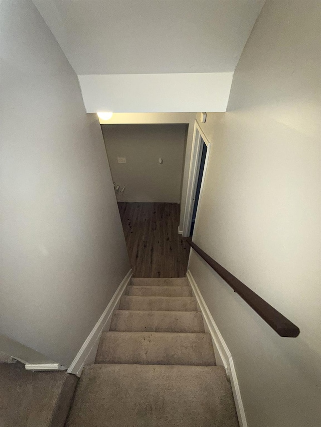 stairway featuring hardwood / wood-style floors and vaulted ceiling