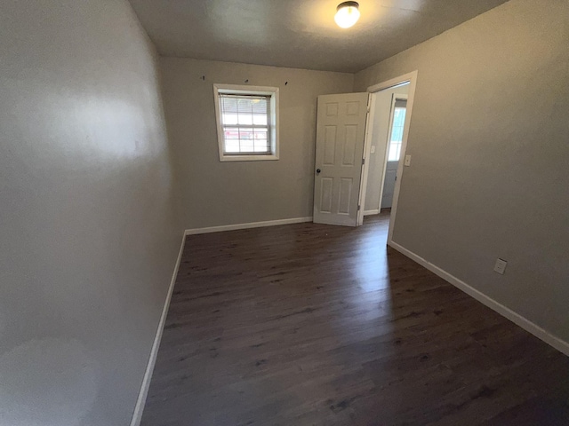 unfurnished room with dark wood-type flooring