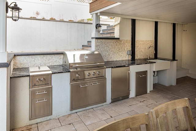 view of patio with exterior kitchen, a grill, and a sink