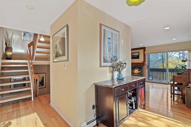 hall featuring a baseboard heating unit and light hardwood / wood-style flooring