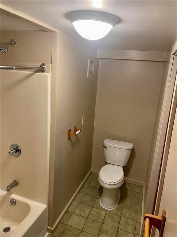 bathroom with tile patterned flooring, tub / shower combination, and toilet