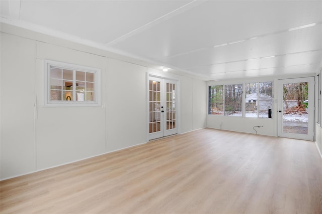 empty room featuring french doors and light hardwood / wood-style flooring