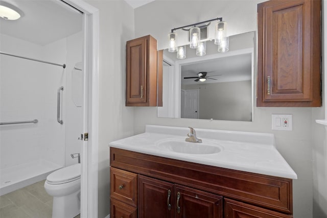 bathroom with a shower, vanity, toilet, and ceiling fan