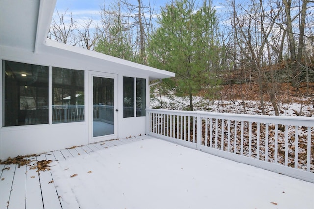 snow covered deck featuring a sunroom