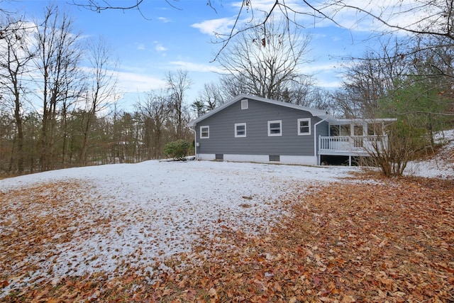 view of snowy exterior featuring a wooden deck