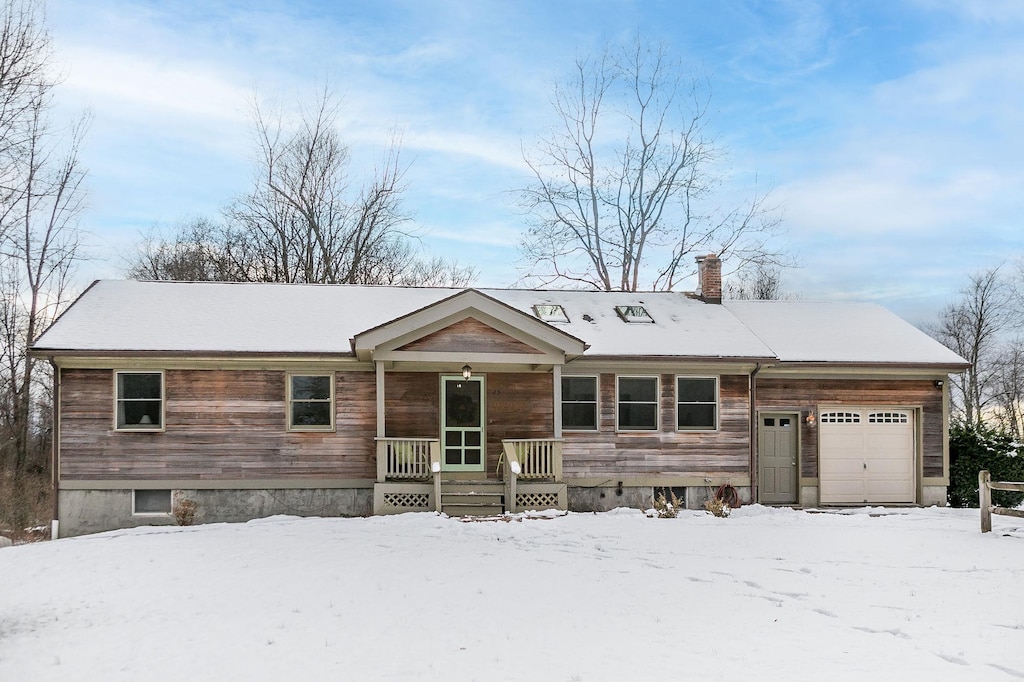 ranch-style home featuring a porch and a garage