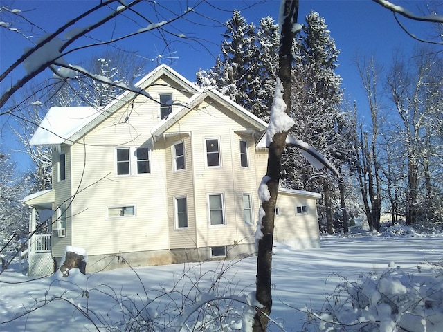 snow covered property featuring central AC unit