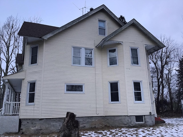 view of snow covered rear of property