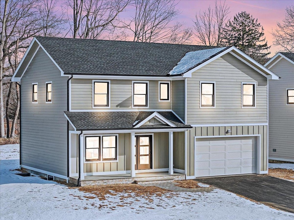 view of property with a porch and a garage