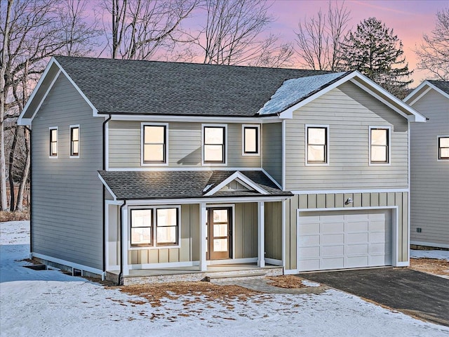 view of property with a porch and a garage