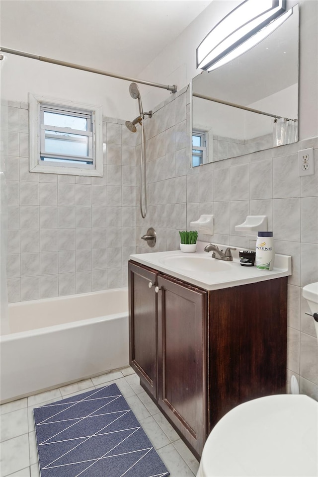 full bathroom featuring tile patterned flooring, vanity, tile walls, and tiled shower / bath