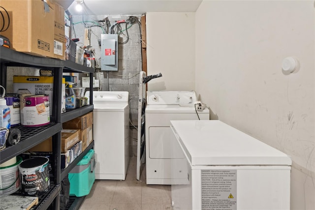 clothes washing area featuring electric panel and washing machine and dryer