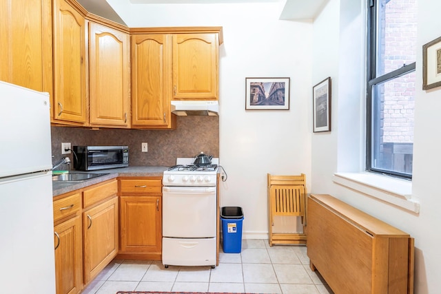 kitchen with sink, light tile patterned floors, white appliances, and backsplash