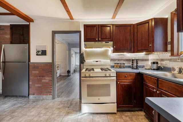 kitchen featuring sink, white gas range oven, stainless steel fridge, light hardwood / wood-style floors, and ornamental molding