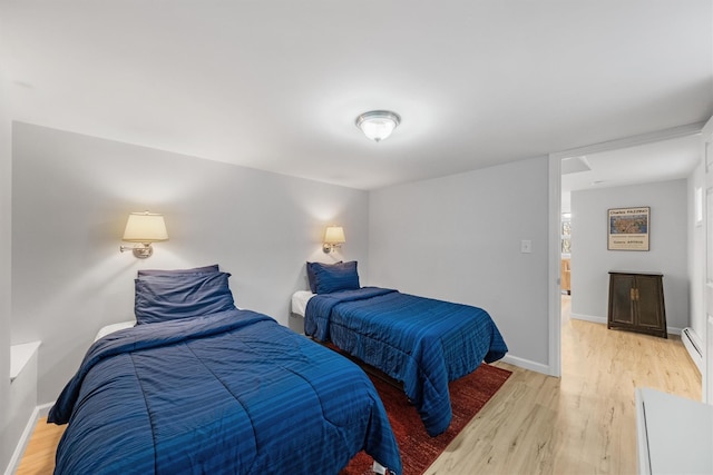 bedroom with light wood-type flooring and a baseboard radiator