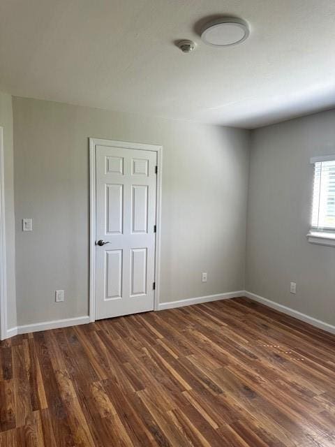 unfurnished room with dark wood-type flooring