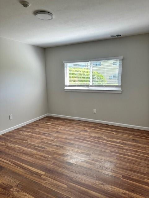 empty room with dark hardwood / wood-style flooring