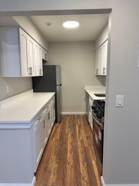 kitchen featuring white cabinets, stainless steel appliances, and dark hardwood / wood-style floors