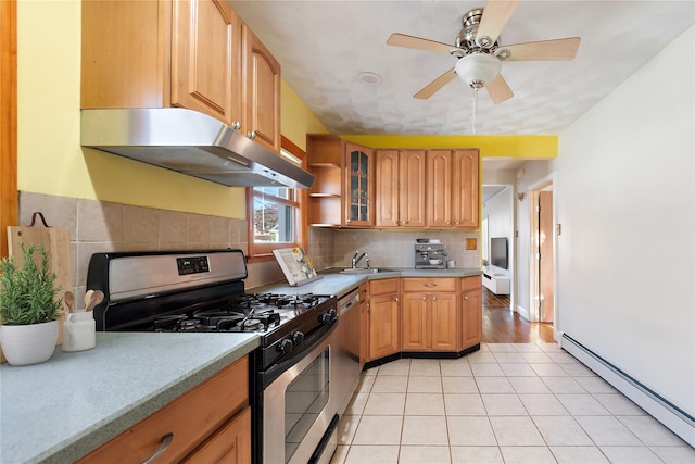 kitchen featuring sink, ceiling fan, appliances with stainless steel finishes, a baseboard radiator, and light tile patterned flooring