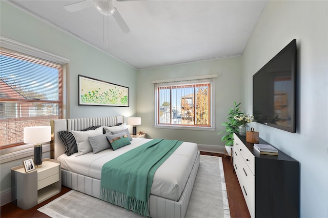 bedroom with ceiling fan, crown molding, dark wood-type flooring, and multiple windows