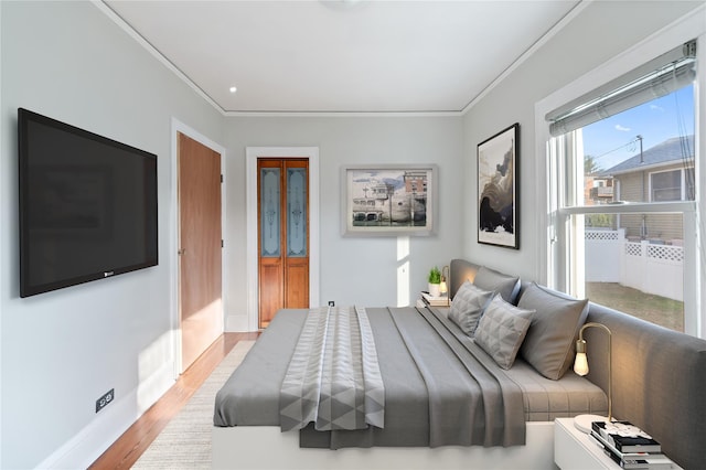 bedroom with light hardwood / wood-style flooring and ornamental molding