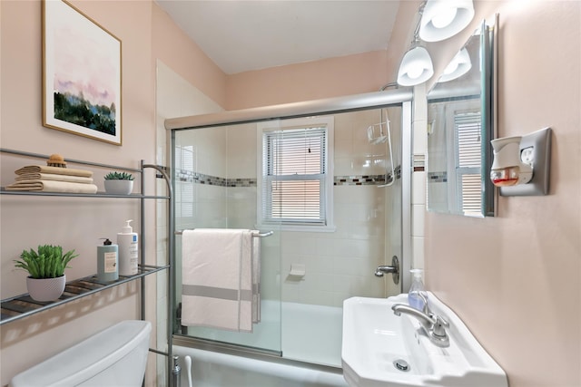 full bathroom featuring sink, enclosed tub / shower combo, and toilet