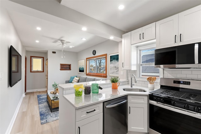 kitchen featuring decorative backsplash, white cabinetry, sink, and appliances with stainless steel finishes