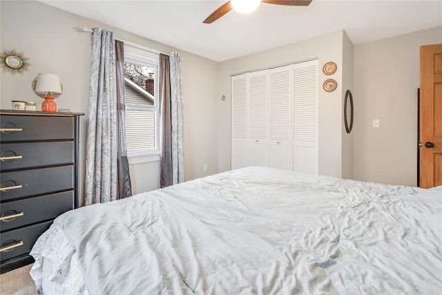 carpeted bedroom featuring ceiling fan and a closet