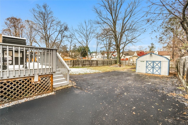 view of yard with a wooden deck and a storage shed