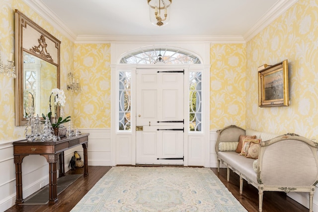 foyer entrance with wallpapered walls, dark wood-style floors, and a wainscoted wall