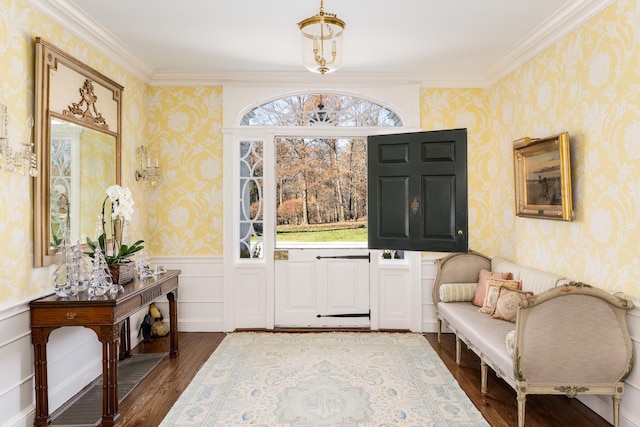 entrance foyer with a wainscoted wall, wood finished floors, and wallpapered walls