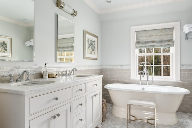 bathroom with a sink, double vanity, a freestanding tub, and crown molding