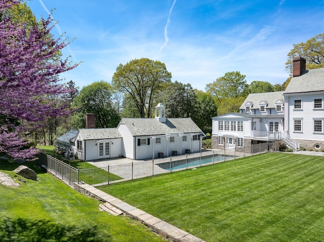 177 Old Briarcliff Rd, Briarcliff Manor, NY 10510 - rear view of property featuring a lawn, a fenced in pool, french doors, and a chimney