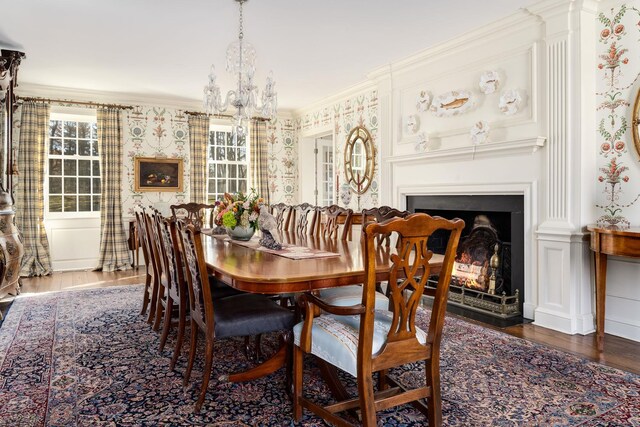 177 Old Briarcliff Rd, Briarcliff Manor, NY 10510 - dining space featuring crown molding, a warm lit fireplace, wood finished floors, and a chandelier