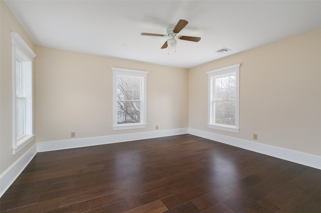 spare room featuring a wealth of natural light, dark hardwood / wood-style flooring, and ceiling fan