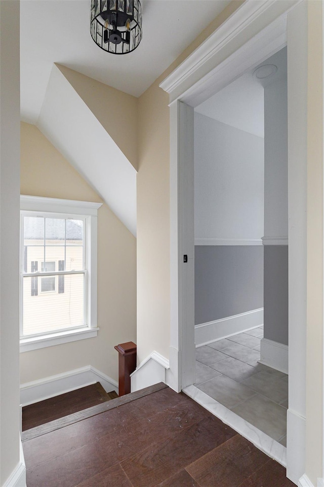 staircase featuring vaulted ceiling and hardwood / wood-style flooring